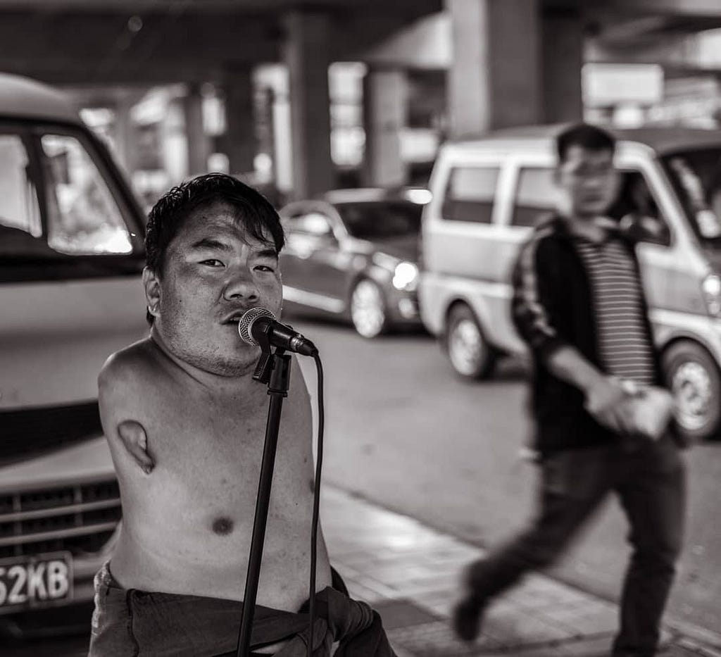 Adedotun Soyebi photographs a survivor sharing his voice on the street of China