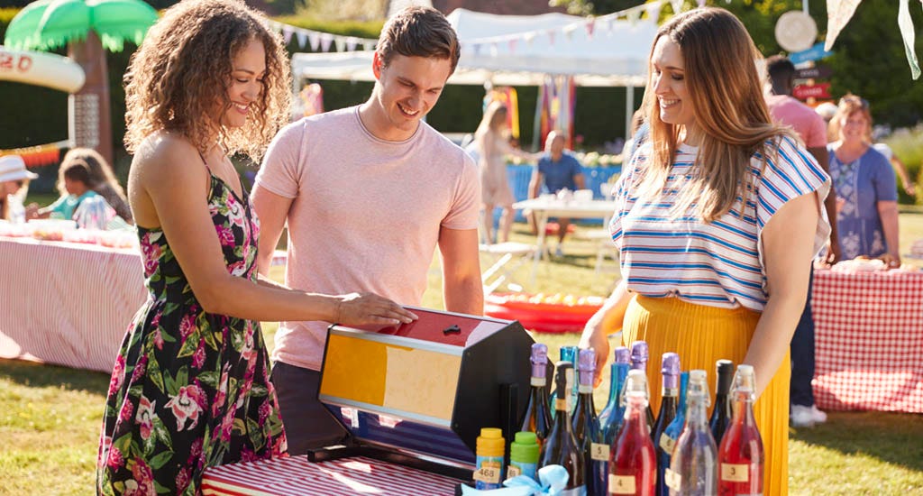 Entrepreneur hosting raffle tickets for wine tasting at an outdoor event