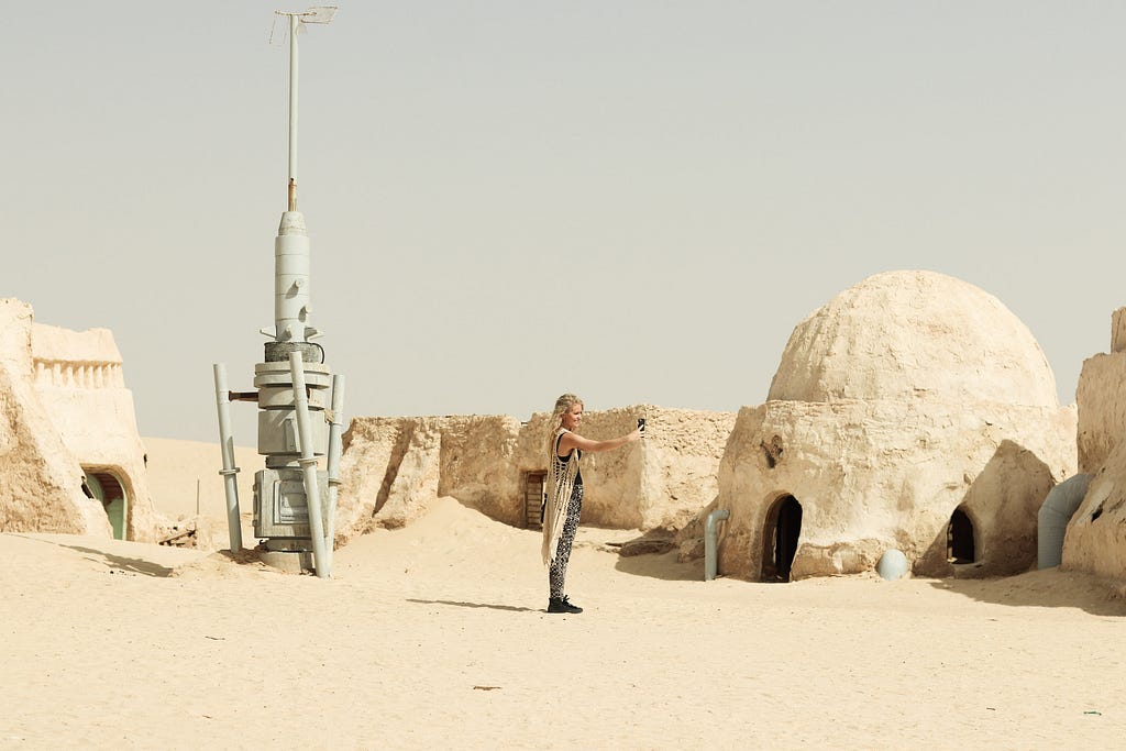 A picture from Star Wars’ Tatooine set. A moisture farmer’s appareture and low domed building sin the desert.