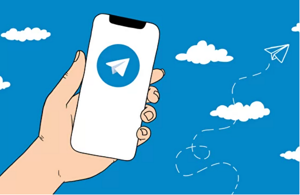 Hand holding a phone. Telegram app logo on the phone.