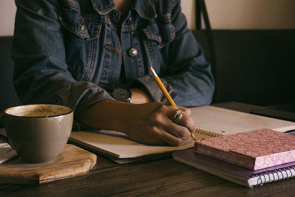 A girl writing in a book.