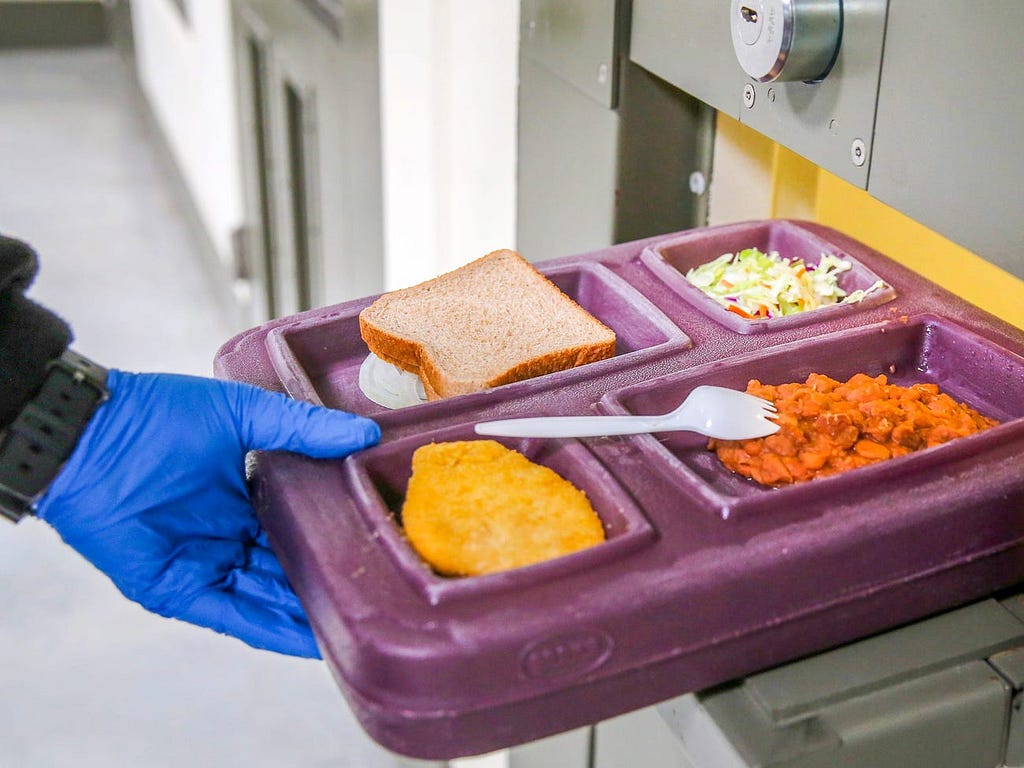 A guard serves lunch to an immigrant detainee in his ‘segregation cell’ during lunchtime at the Adelanto Detention Facility.