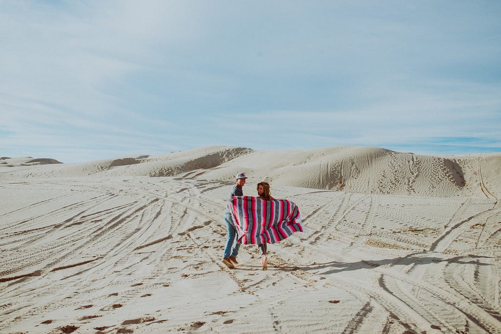 Two people enjoying a walk in a desert scene.