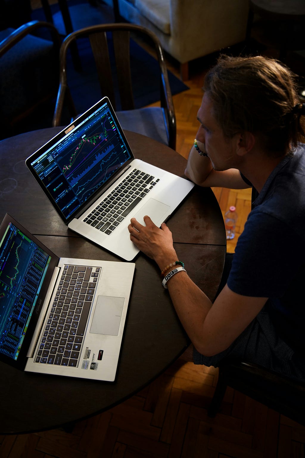 saas magic number metric, man with two laptops and each screen shows data and graphs