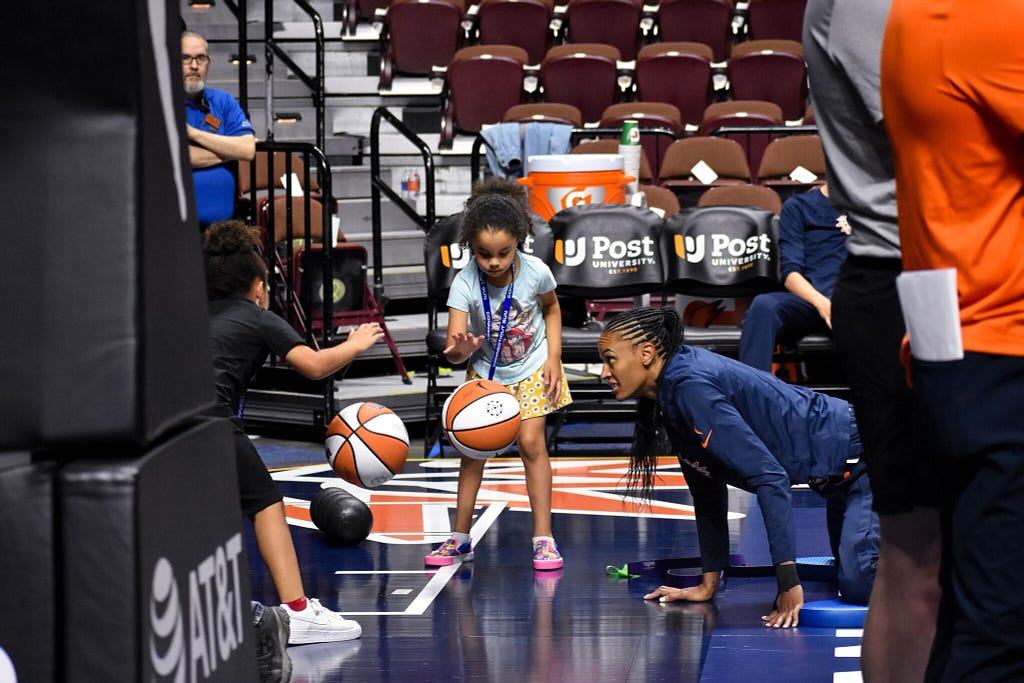 DeWanna Bonner entertains her twin girls as they dribble WNBA basketballs