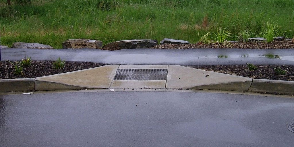 A sidewalk with a curb cut that slopes down, making it easier for vehicles such as strollers and wheelchairs to access.