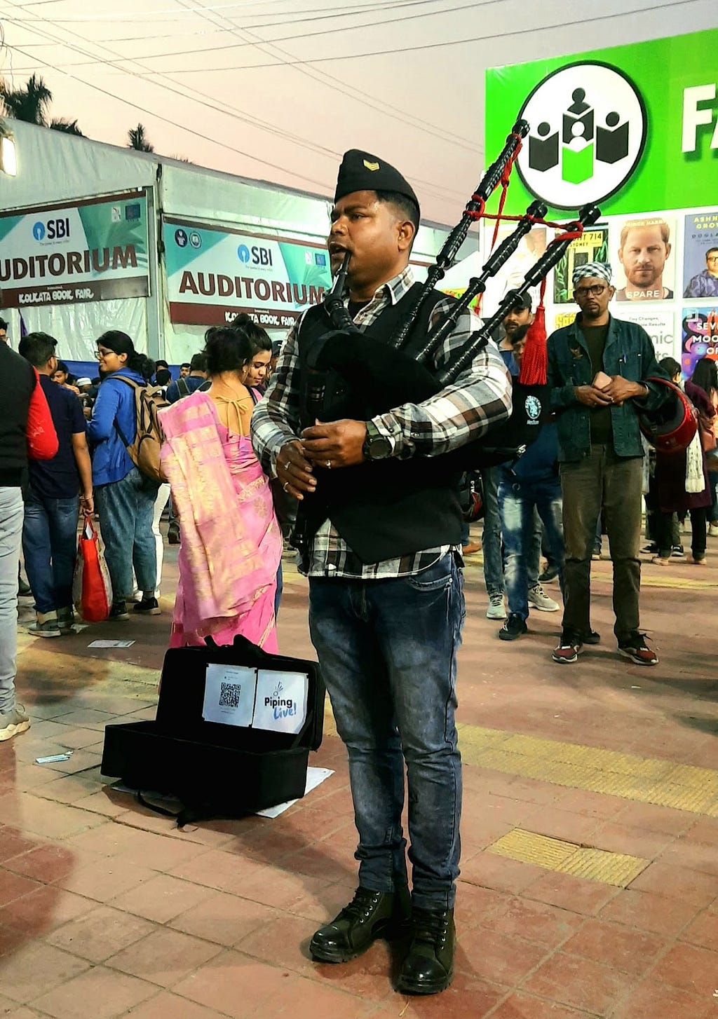 A bagpiper playing his bagpipe amongst the crowd inside Kolkata Book Fair 2023