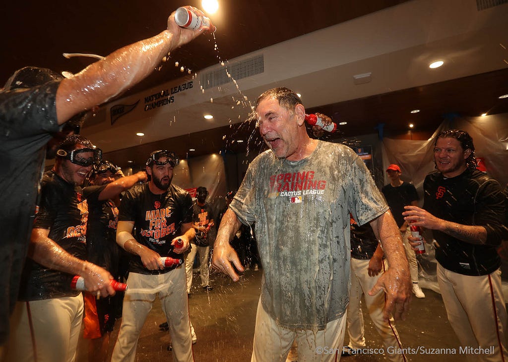 Bruce Bochy gets showered with beer in the clubhouse.