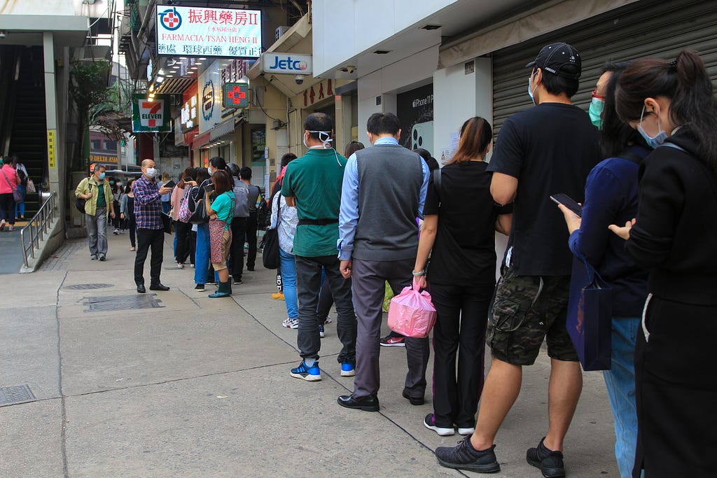 People waiting in line on a sidewalk in Vietnam