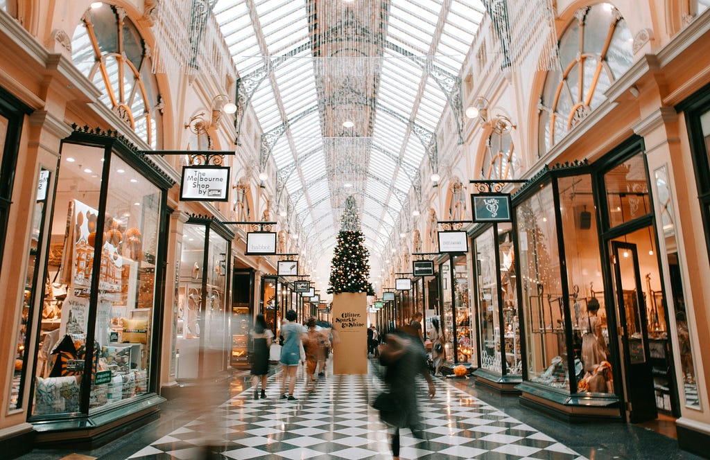 A picture inside of a mall where are many shops in the left and right side.