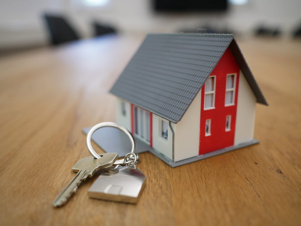 A miniature model of a house with a key.