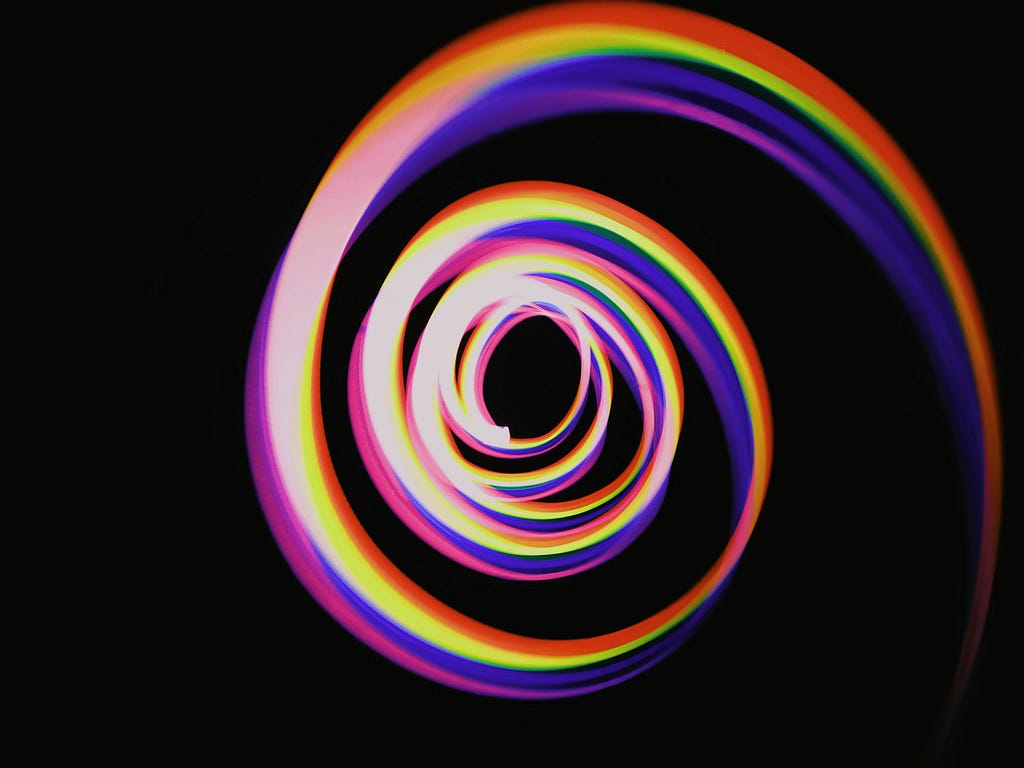 Photo of a colorful light spiral outlining a magical shell like structure.