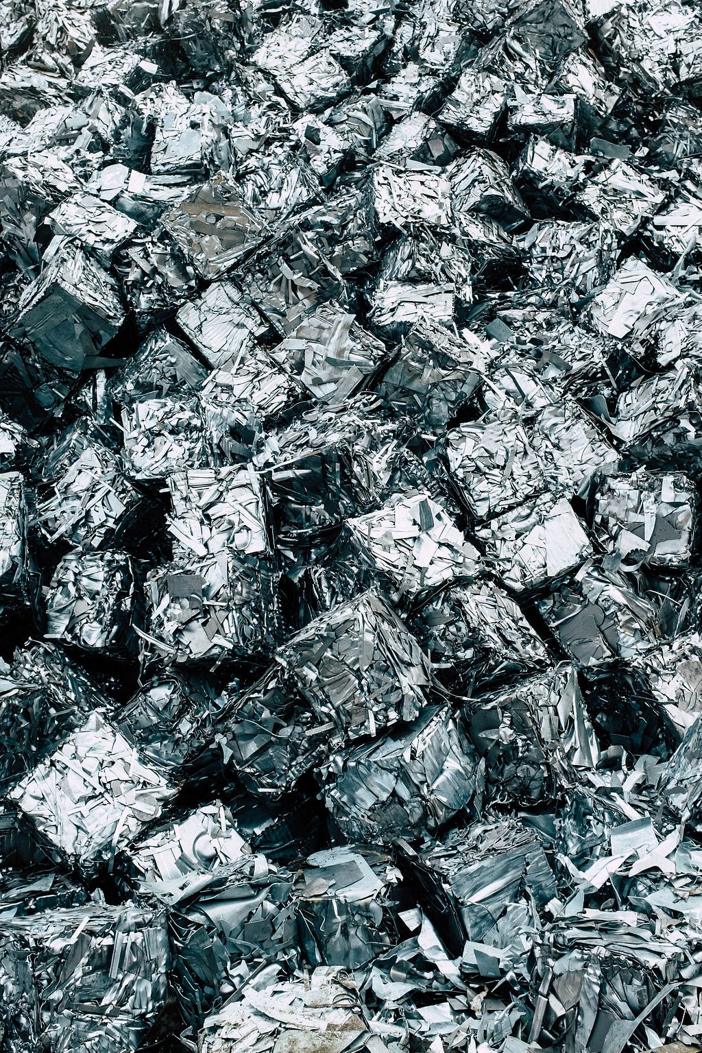 A large number of metal cubes of trash in a landfill.