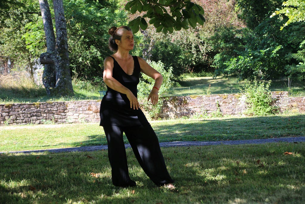 A lady doing Tai Chi in the park.