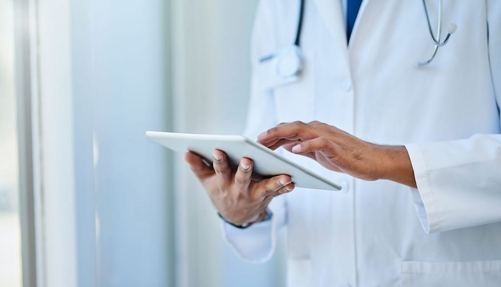 Doctor scrolls on digital tablet