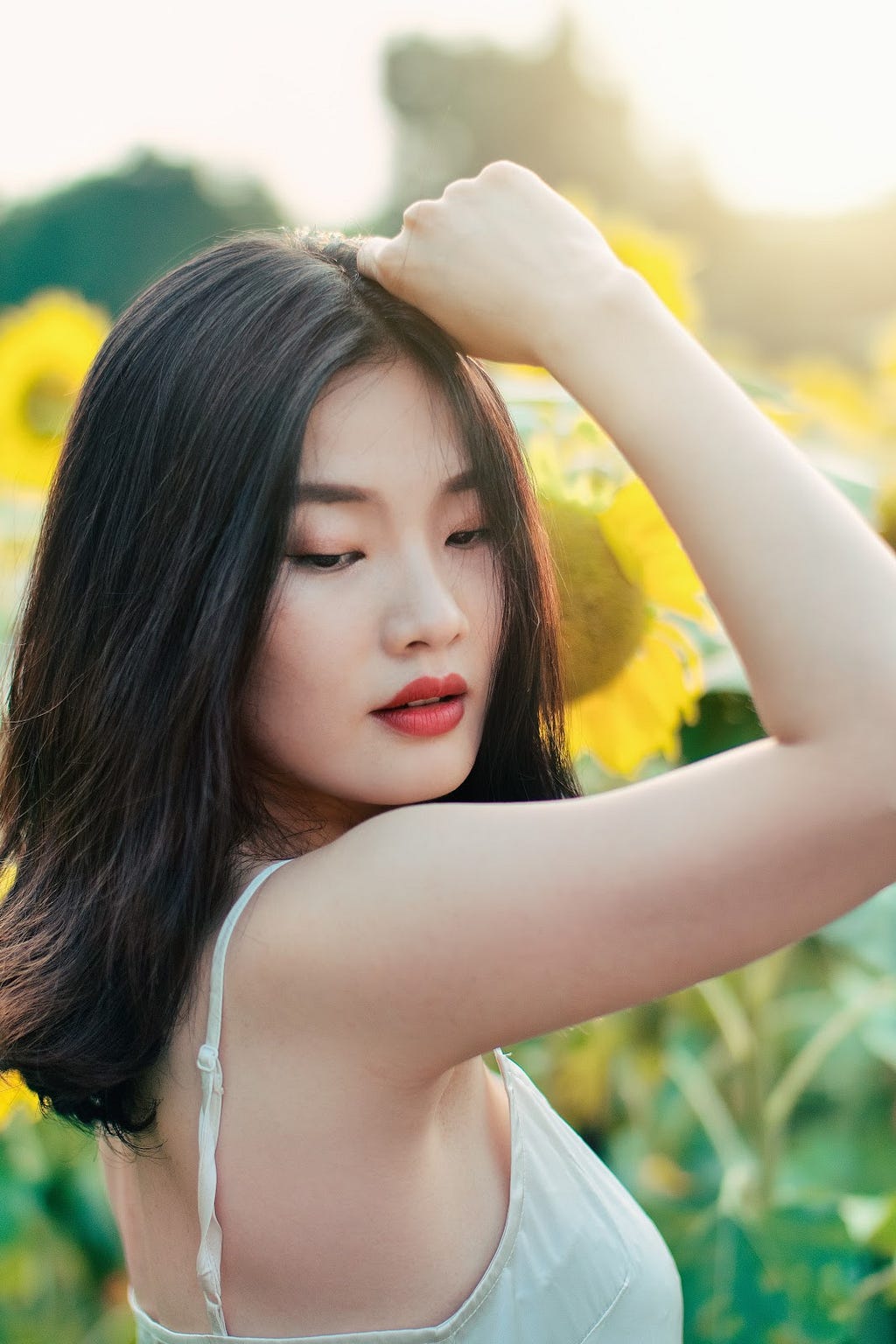 A photo of an Asian woman in a white tank top