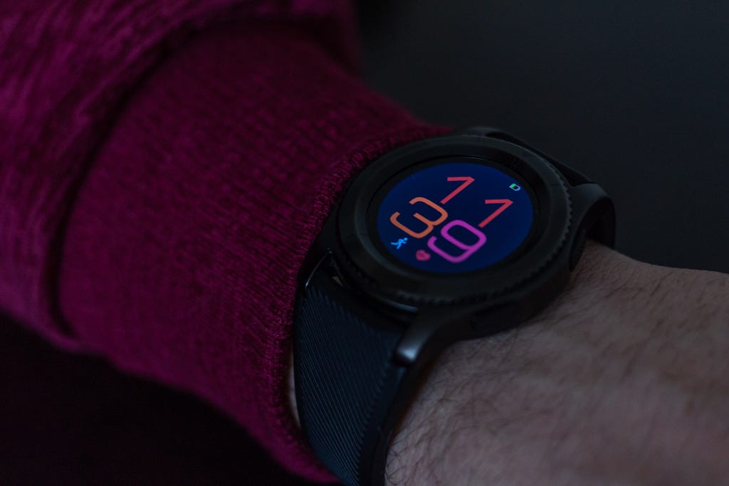 A close up of a smart watch telling the time and tracking the wearers heart rate and running speed