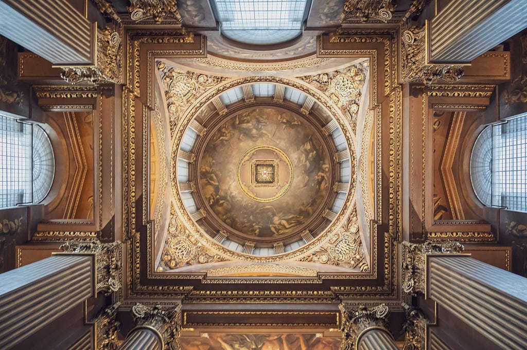 An intricately detailed ceiling of a grand architectural structure, likely a cathedral or palace, viewed from directly below.