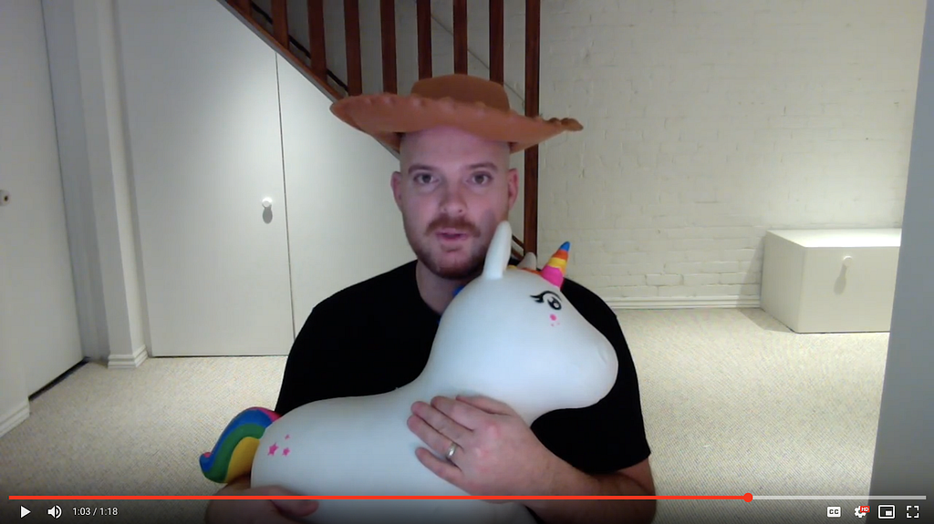 The author in a plastic cowboy hat, clutching a rainbow unicorn.