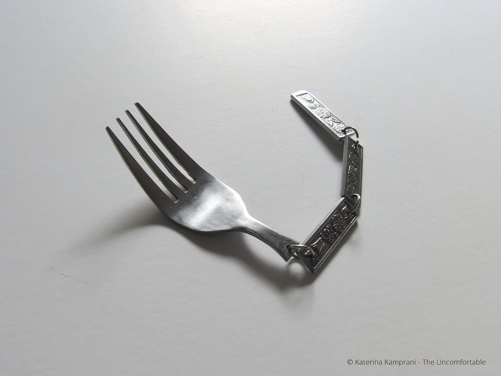 A fork with a linked decorative chain for a handle. Completely useless. Another art piece from Katerina Kamprani to symbolize the danger of a broken user experience.