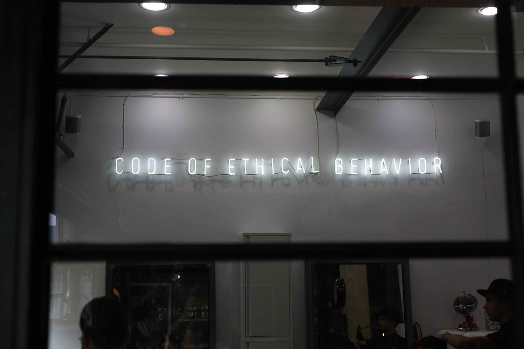 A wall with “Code of Ethical Behavior” in lights.
