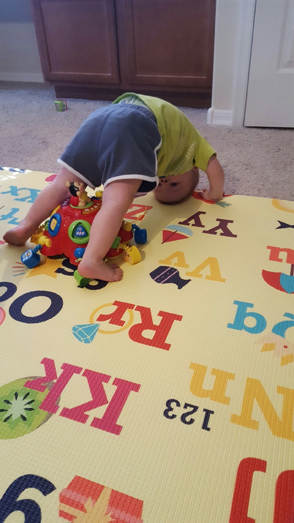 Young toddler boy standing in a Downward-Facing Dog pose.