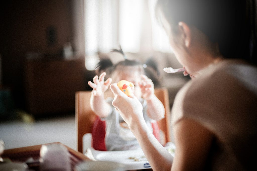 Mother feeding baby in kitchen