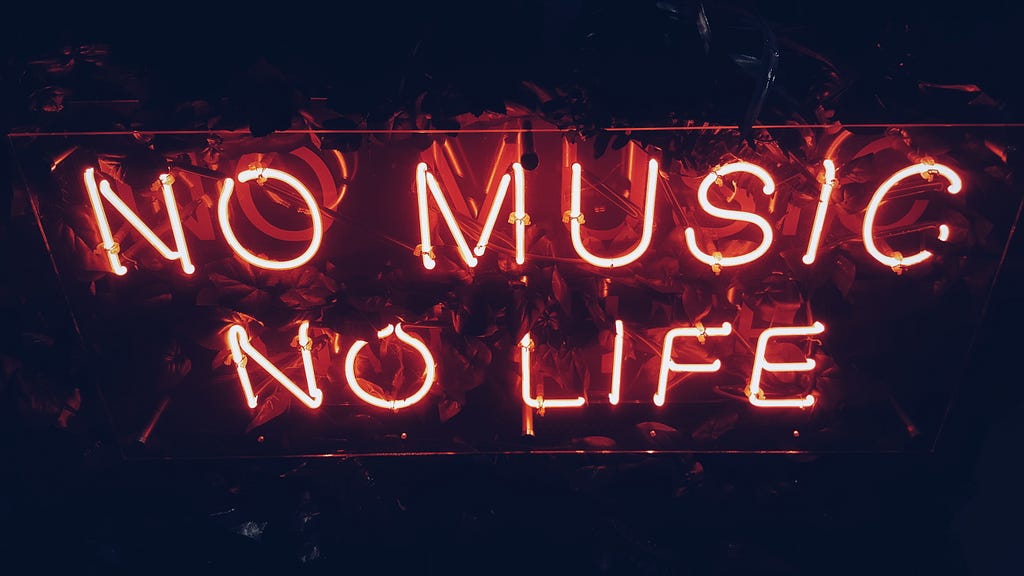 A red fluorescent sign reading “No music, no life”