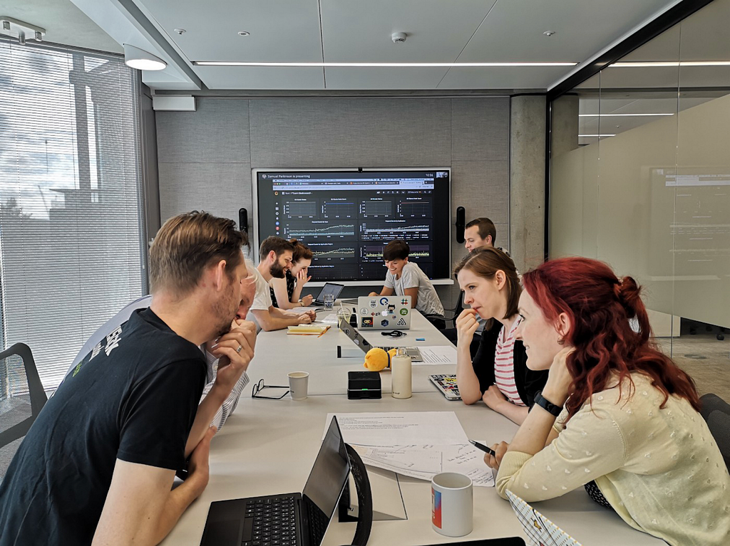 A group of people sat round a table with laptops and metrics displayed