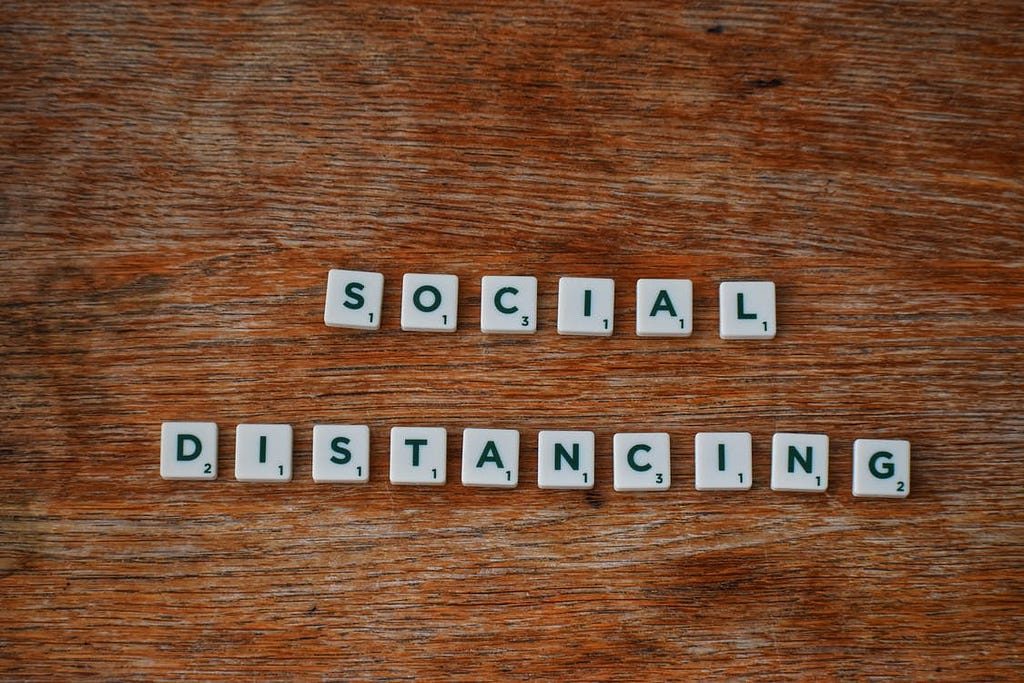 Scrabble tiles spelling out the words social distancing