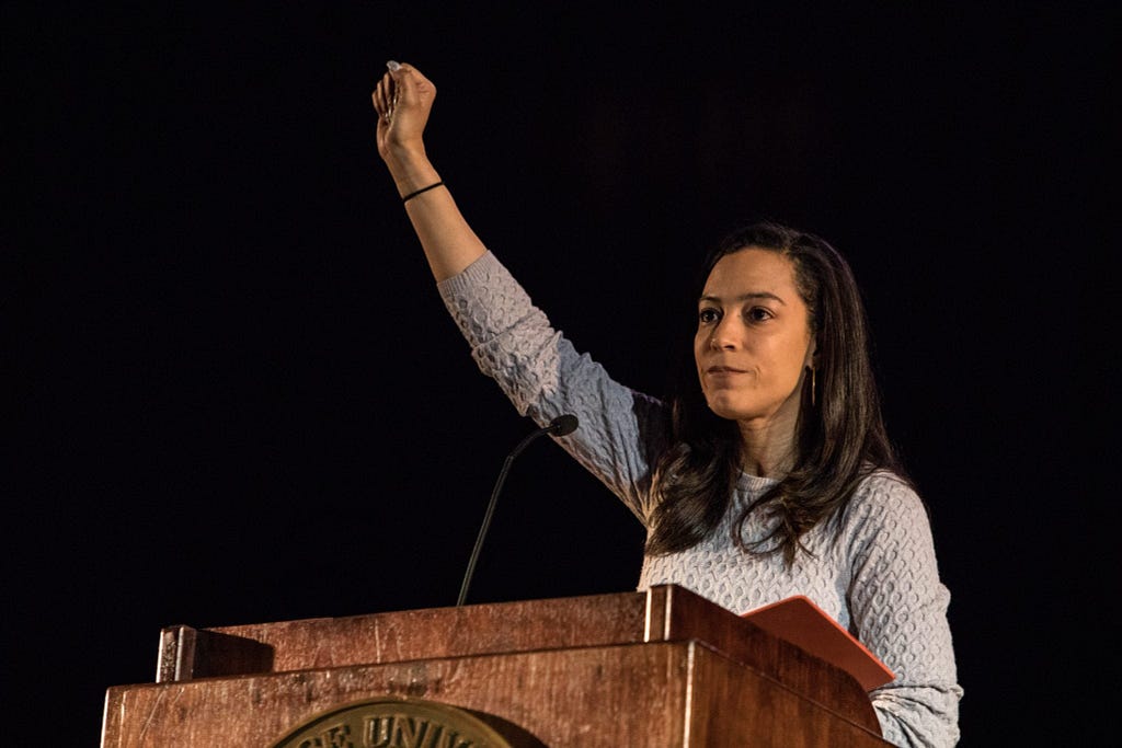 Photo of Angela Rye with her right fist raising during her speaking engagement at MLK Celebration. 2018