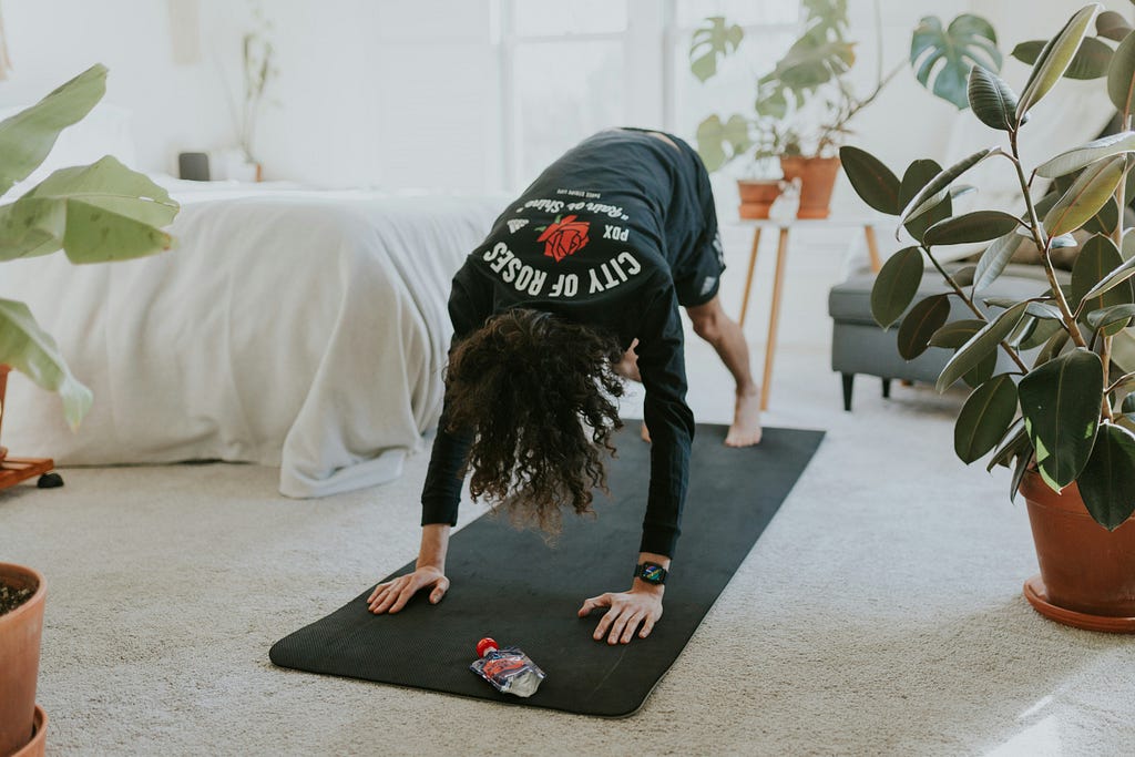 An at home employee doing yoga in her bedroom