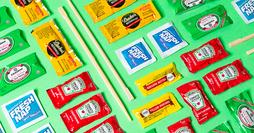 A stylized shot of food delivery freebies: chopsticks, condiment packets, wet wipes