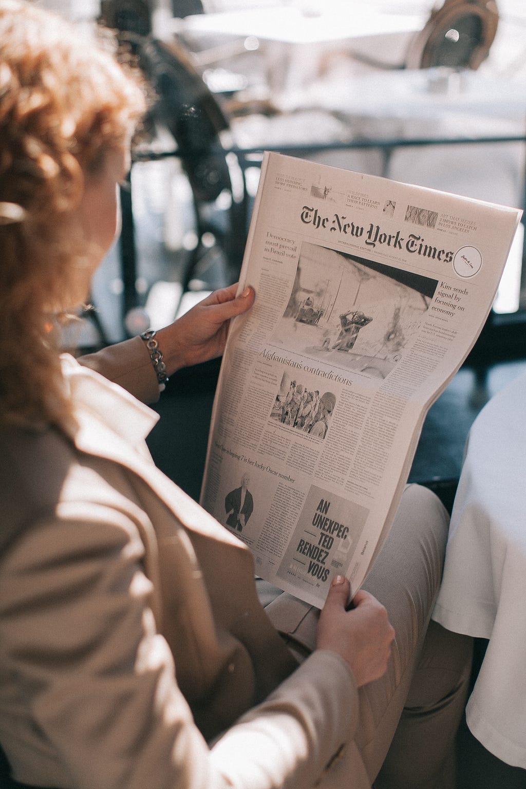 A woman is reading newspaper.