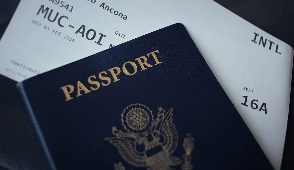 Photo of the cover of a passport and a plane ticket