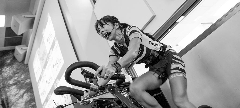 female spin class instructor on a bike
