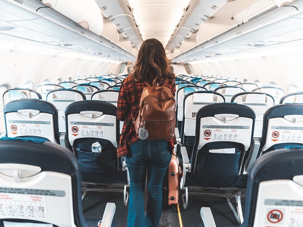 A woman boards a plane.