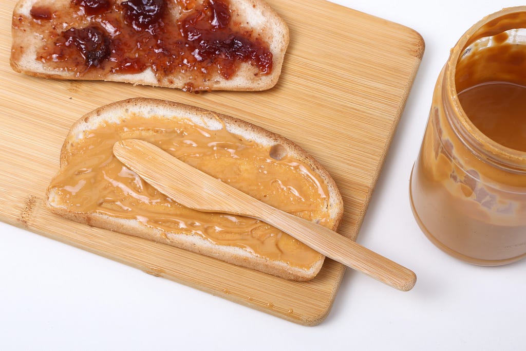 Photograph of a peanut butter and jelly sandwich being made.