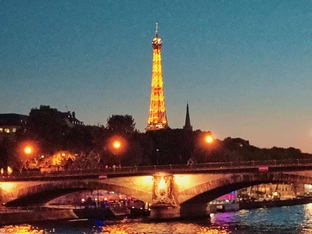 The eiffel tower is lit up at dusk in paris.