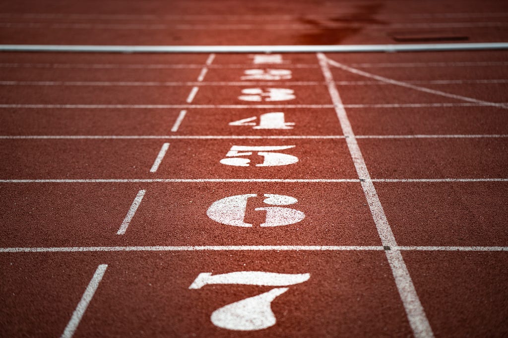 Numbers painted on a track for running, with a warm-colored hue to the photo