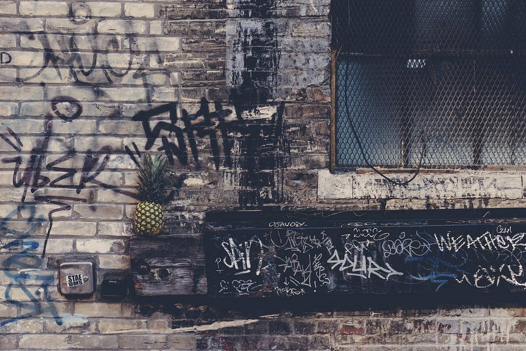 Photograph of graffiti covered masonry wall, with overlapping tags.