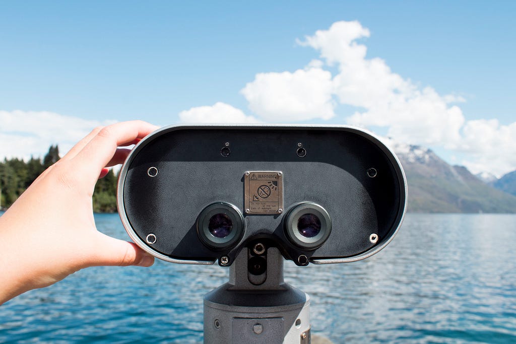 Binoculars looking off into lake scene.