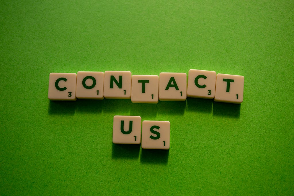 green background with the letters spelling out, “contact us” on individual blocks