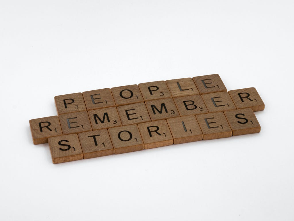 Scrabble tiles spelling out, “People remember stories.”