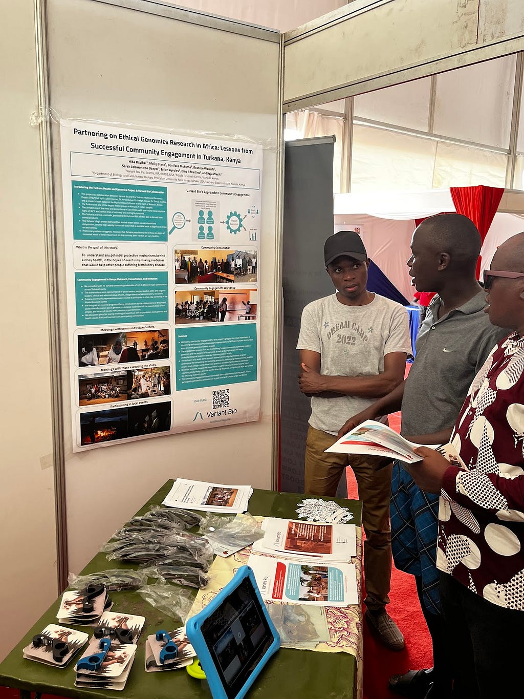 Alex Wanyonyi Mutongoi and Echwa John (left and middle) from the project team explaining Variant Bio’s involvement in the research and approach to community engagement to a festival attendee (right).