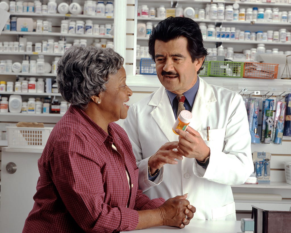 An elderly woman consulting a pharmacist