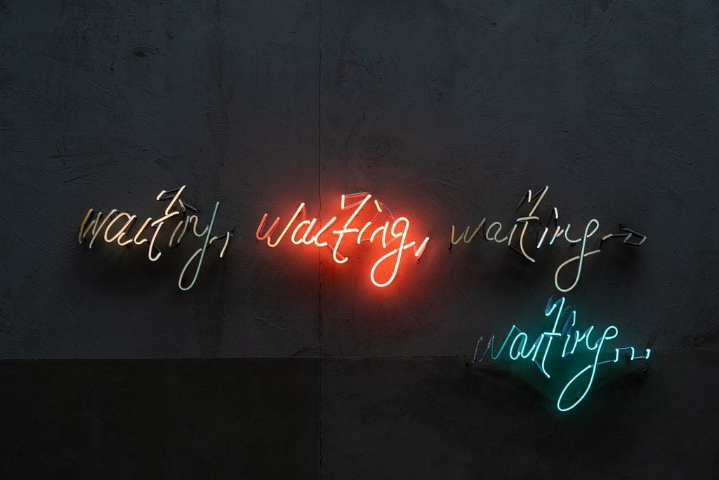 Neon signs with that says “waiting, waiting, waiting, waiting…”