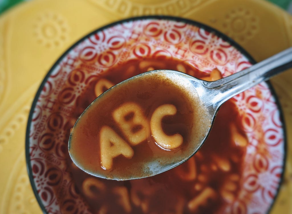 Bowl of alphabet soup with A-B-C in a spoon of broth