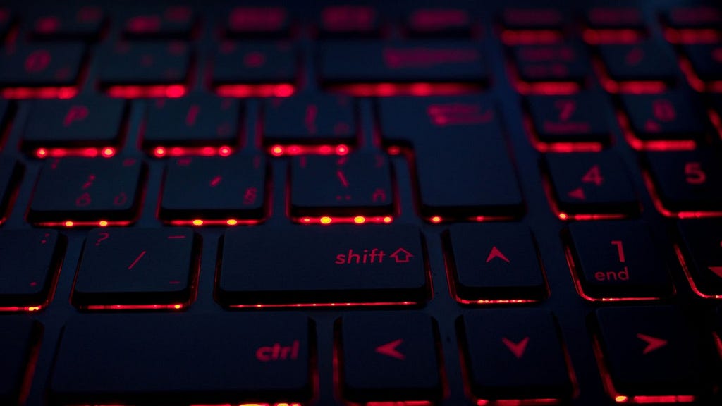 A close-up photo of a keyboard backlit with red lighting