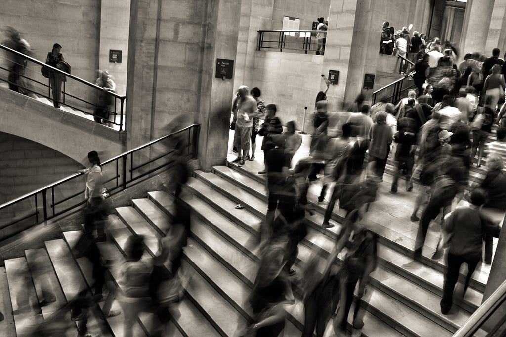 a photo of people rushing about in a building